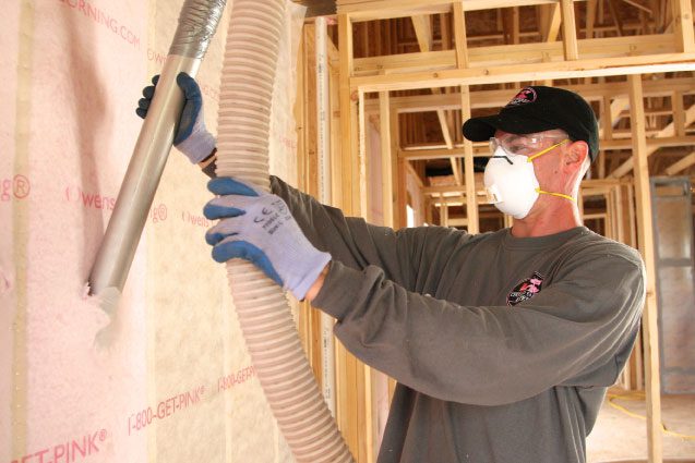 An insulation contractor installing a blown-in wall system in a commercial building in Charlotte
