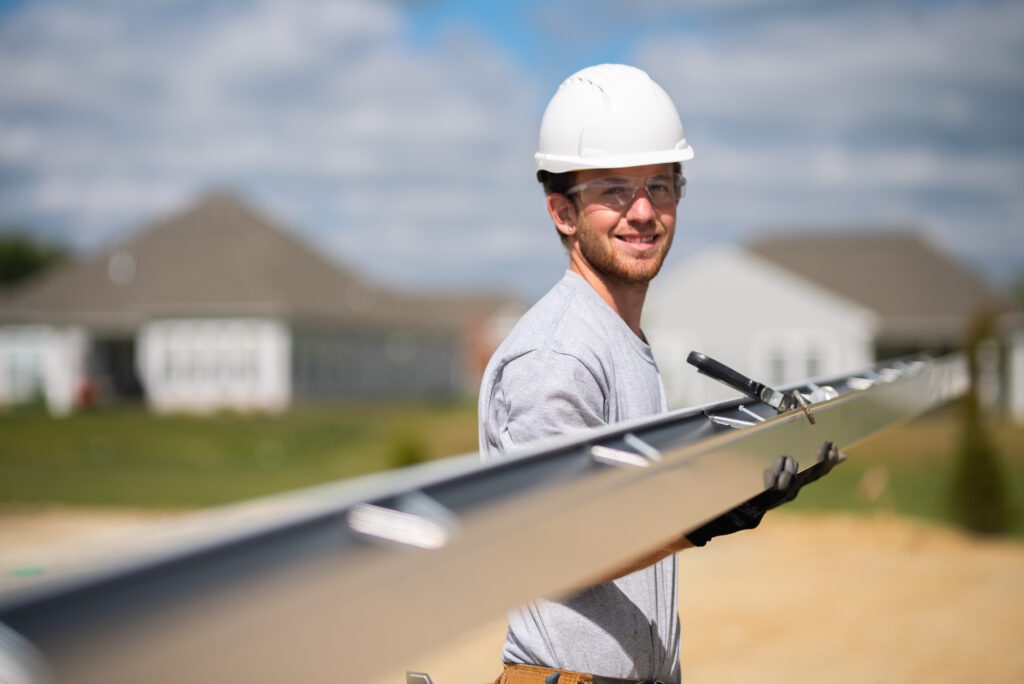 A gutter installer installing new gutters on a commercial building
