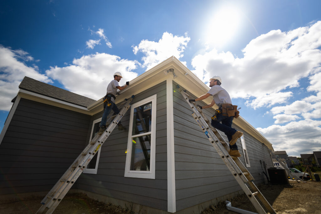 Contractors installing gutters on a new build residential home