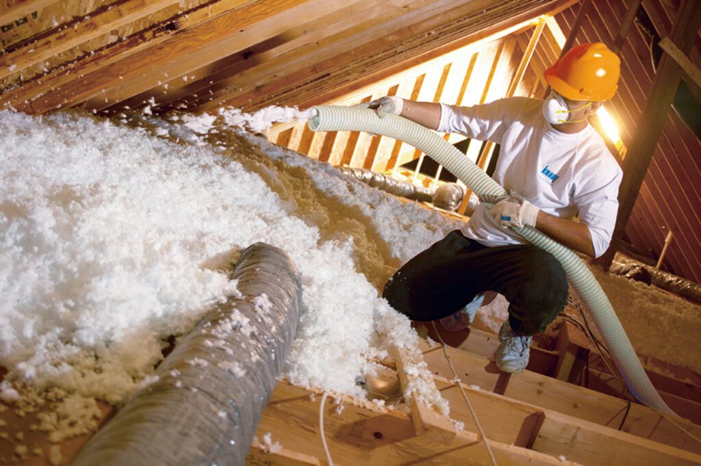 Knauf fiberglass blown-in insulation being installed in an attic in Charlotte