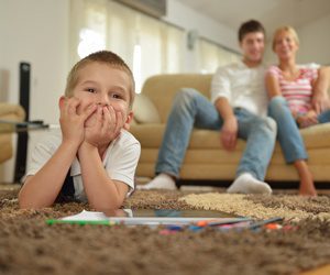 happy young family with kids in bright modern living room